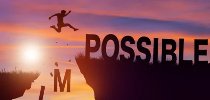 Person jumping between two rocks as the word 'Impossible' changes to 'Possible' with the 'IM' falling away.